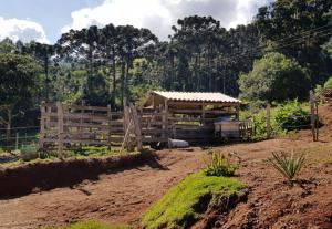 um edifício num campo com uma vedação em Chalé no campo à caminho de Monte Verde em Camanducaia