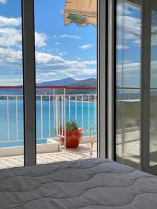 a bedroom with a view of the ocean from a window at Mimoza's Sea View Apartment in Paleo Tsifliki