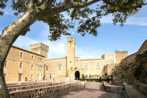 a view of a castle with benches in front of it at La Suite TAMAN au centre de Salon in Salon-de-Provence