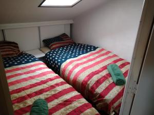 - 2 lits dans une petite chambre avec une couverture américaine dans l'établissement Appartement Port Rose 2, à Leucate