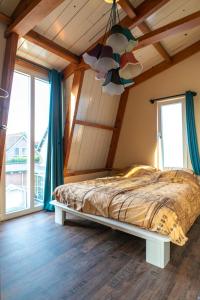 een slaapkamer met een bed in een kamer met ramen bij klein polderhuis - bollenschuur in Roelofarendsveen