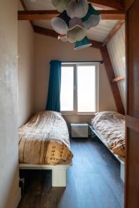 een slaapkamer met 2 bedden en een plafondventilator bij klein polderhuis - bollenschuur in Roelofarendsveen