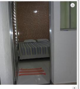 a small bedroom with a bed in a room at Pousada PG One in Praia Grande