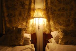 a lamp sitting next to two beds in a room at Hadrian's Barn in Heddon on the Wall