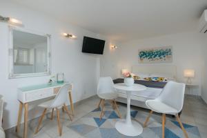 Apartments Zicara في دوبروفنيك: غرفة معيشة بيضاء مع طاولة وكراسي