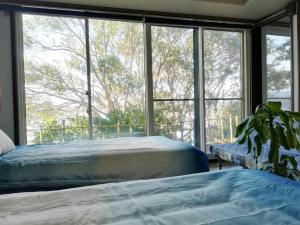 two beds in a bedroom with a large window at Lake Front House Aozora - Vacation STAY 27631v in Sado