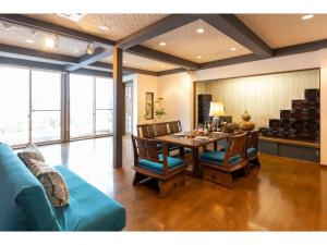 salon ze stołem i niebieską kanapą w obiekcie Lake Front House Aozora - Vacation STAY 27631v w mieście Sado