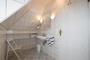 a white bathroom with a sink and a staircase at Hüs Auert Tharep, Wohnung 3 in Hörnum