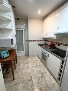 a kitchen with white cabinets and a wooden table at Luxury Family Homes K in Salamanca