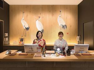 two women standing at a counter with birds on the wall at Kamon Hotel Namba - Vacation STAY 37041v in Osaka