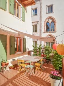 a patio with a table and chairs and a building at BeautyfoodLAB in Arco