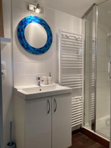 a bathroom with a sink and a mirror and a shower at LE CHALET de LA LONGERE in Beuvry-Nord