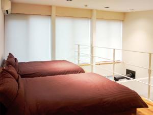 Cette chambre comprend un grand lit et de grandes fenêtres. dans l'établissement Forest Villa Nanso no Oka - Vacation STAY 39406v, à Minamiboso