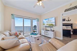 a living room with a couch and a tv at Crystal Tower 1408 - Lazy River, Beachfront pool, Amazing Views, New Upgrades!! in Gulf Shores +29 photos