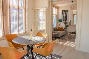 a dining room with a table and chairs and a living room at Stylish City apartments Middelburg in Middelburg