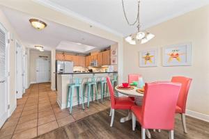 a kitchen and dining room with a table and chairs at Crystal Tower 1408 - Lazy River, Beachfront pool, Amazing Views, New Upgrades!! in Gulf Shores
