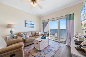 a living room with a couch and a table at Crystal Tower 1408 - Lazy River, Beachfront pool, Amazing Views, New Upgrades!! in Gulf Shores