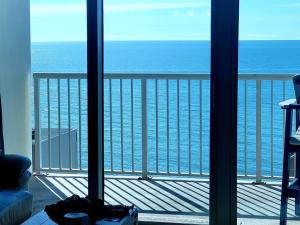 a room with a view of the ocean from a balcony at Crystal Tower 1408 - Lazy River, Beachfront pool, Amazing Views, New Upgrades!! in Gulf Shores