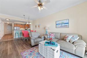 a living room with a couch and a table at Crystal Tower 1408 - Lazy River, Beachfront pool, Amazing Views, New Upgrades!! in Gulf Shores