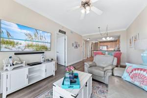 a living room with a couch and a tv at Crystal Tower 1408 - Lazy River, Beachfront pool, Amazing Views, New Upgrades!! in Gulf Shores