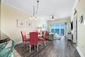 a dining room and living room with a table and chairs at Crystal Tower 1408 - Lazy River, Beachfront pool, Amazing Views, New Upgrades!! in Gulf Shores