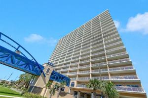a tall building with palm trees in front of it at Crystal Tower 1408 - Lazy River, Beachfront pool, Amazing Views, New Upgrades!! in Gulf Shores