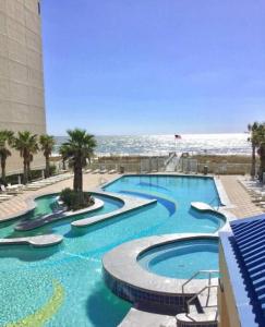 a large swimming pool next to the beach at Crystal Tower 1408 - Lazy River, Beachfront pool, Amazing Views, New Upgrades!! in Gulf Shores