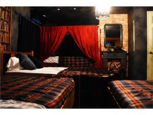 a bedroom with two beds and a red curtain at Expected Inn - Vacation STAY 41403v in Fukuoka