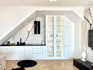 a kitchen with white cabinets and a staircase at Apartament Masuria Sky w Nautica Resort z widokiem na jezioro Niegocin in Giżycko