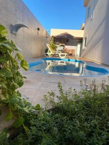 a swimming pool in a yard next to a building at COMFORT DUPLEX in Rio das Ostras