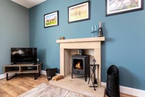 a living room with a fireplace and a tv at The Hideaway @ Watergate eye Farm in Barnard Castle