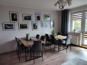 a dining room with tables and chairs and pictures on the wall at Willa Orle Gniazdo in Biały Kościół