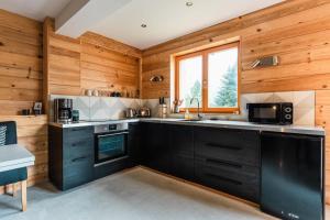 a kitchen with black cabinets and a window at Duplex Chamonix Les Houches in Les Houches