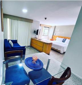uma sala de estar com uma cama e uma mesa de vidro em Apê Beira Mar Meireles Com café da manhã em Fortaleza