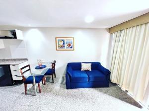 Una sala de estar con un sofá azul y una mesa. en Apê Beira Mar Meireles Com café da manhã, en Fortaleza