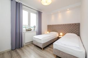 a hotel room with two beds and a window at Apartamenty Usteckie Wydma in Ustka