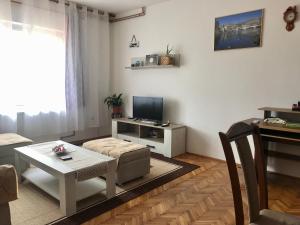 ein Wohnzimmer mit einem Sofa und einem Tisch in der Unterkunft Apartmani RADA in Trebinje