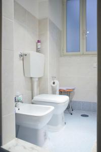 a white bathroom with a toilet and a window at Appartamento Reginella in Naples