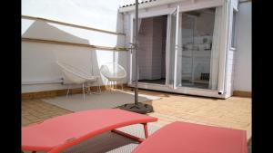 een balkon met een rode stoel en een tafel bij Entre Catedrales Terrace in Sevilla