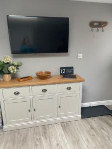 a white dresser with a flat screen tv on a wall at Lytham Sea Salt Lodge in Lytham St Annes