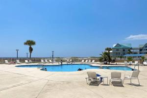 einen Pool mit 2 Stühlen, einem Tisch und Stühlen in der Unterkunft Royal Gulf Beach and Racquet Club-5615-Beachfront Luxury! Near Kiva Dunes Golf in Gulf Shores