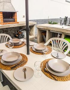 einen Tisch mit Tellern und Weingläsern darauf in der Unterkunft Caleta de Interian Loft Sasy in Los Silos