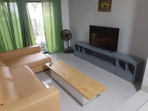 sala de estar con sofá y TV de pantalla plana en Apartamento T1 Moderno com Wi-Fi, en Praia