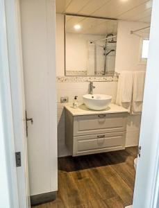 ein weißes Badezimmer mit einem Waschbecken und einem Spiegel in der Unterkunft Caleta de Interian Loft Sasy in Los Silos