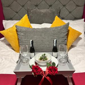 a table with a plate of food and two bottles of wine at Luxury apartment by the waterfront-5 min walk to shopping centre & other amenities Contractors welcome in Brierley Hill