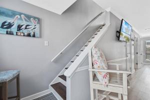 eine weiße Treppe in einem Zimmer mit Treppenaufgang in der Unterkunft South Winds unit 2-Gorgeous Newly Updated Condo in the Heart of Gulf Shores!! in Gulf Shores