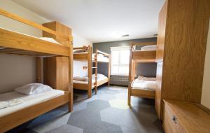 a room with three bunk beds and a hallway at HI Calgary City Centre - Hostel in Calgary