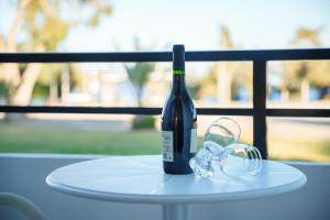 Konnos Bay Gardens في بروتاراس: زجاجة من النبيذ موضوعة على طاولة مع أكواب