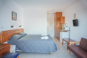 een kleine slaapkamer met een bed en een bank bij Konnos Bay Gardens in Protaras