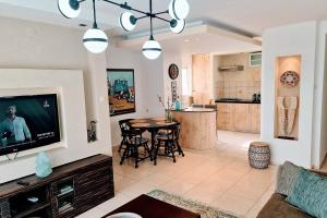 a living room with a television and a table with chairs at Rotem Home in Haifa